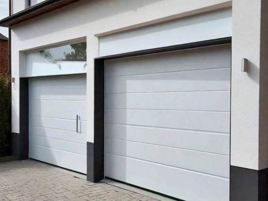 Two modern white garage doors with a horizontal micro-groove design and sleek vertical hardware, installed on a minimalist contemporary home.